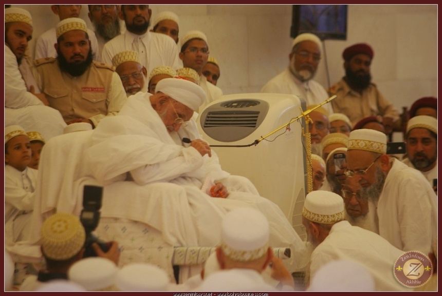 Syedna RA holding the mic with his hands and performing Nass.
