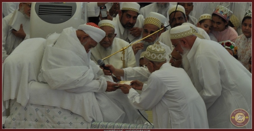 Syedna RA stretching his hands out accepting the najwa tray.